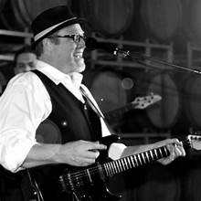 Cory performing on guitar in a winery venue